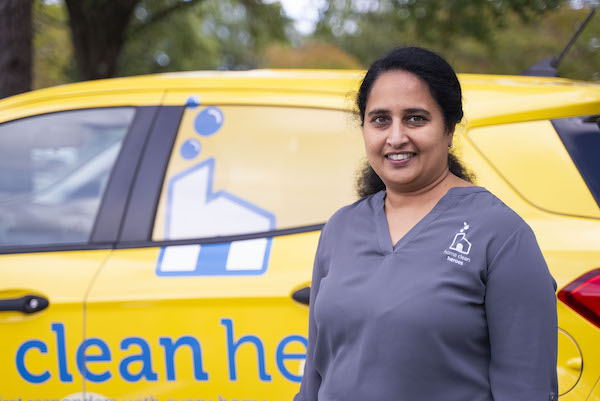 Home Clean Heroes of Atlanta North owner Poolani smiling in front of vehicle