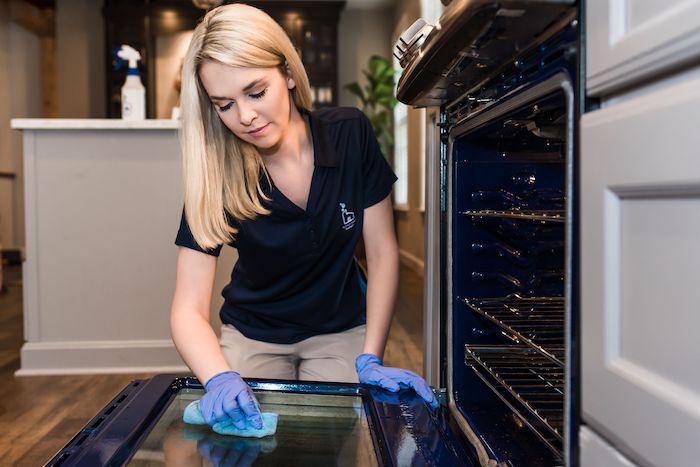 Cleaning specialist scrubbing inside of oven as an add-on service 