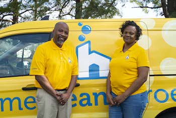 Home Clean Heroes of Augusta owners Tony and Antoinette smiling in front of Home Clean Heroes vehicle