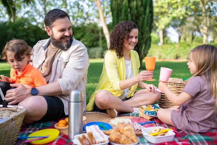 Family of four having a picnic in the park