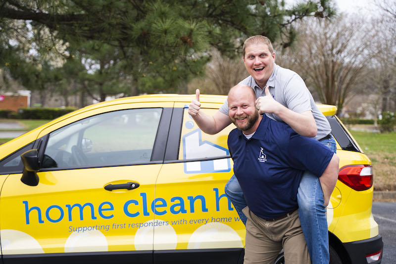 Home Clean Heroes owners in front of their vehicle and having fun