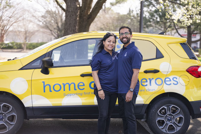 Home Clean Heroes owners Khan and Shermeen in front of Home Clean Heroes vehicle smiling