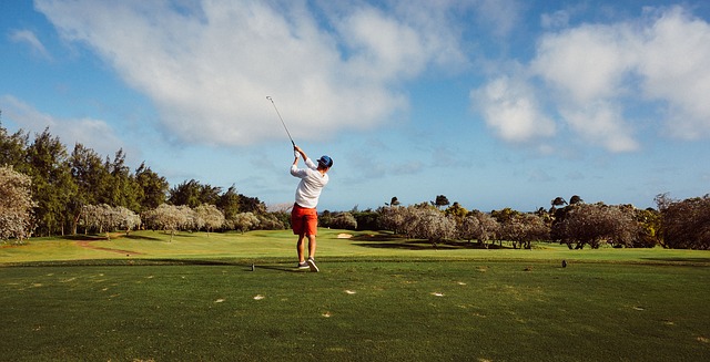 Man swinging a golf club on golf course in Windermere, FL