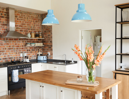 Kitchen with exposed brick wall and blue hanging lights