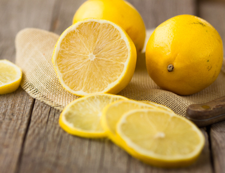 Lemons and lemon slices on wooden table
