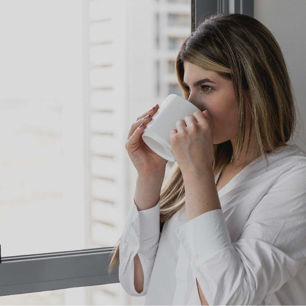 Woman sitting in her house relaxing and sipping coffee