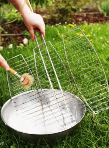 Cleaning a grill grate with a scrub brush