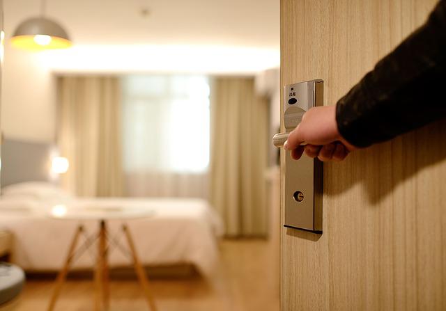 Person opening a door handle into a hotel room