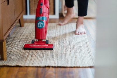 Person vacuuming a rug